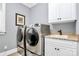 Bright laundry room featuring gray washer and dryer, and a utility sink at 162 Kenway Loop, Mooresville, NC 28117