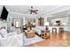 Open living room with hardwood floors, ceiling fan, columns, and a view of the kitchen and dining area at 162 Kenway Loop, Mooresville, NC 28117