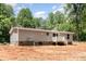 Back view of a one-story house, set in a wooded lot, showing rear entrance deck at 1785 Doe Ct, Iron Station, NC 28080
