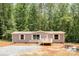 Charming single-story home with gray siding, white trim, and a cozy front porch nestled amongst mature trees at 1785 Doe Ct, Iron Station, NC 28080