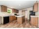 A functional kitchen featuring wood cabinets, black appliances, and a center island for efficient meal preparation at 1785 Doe Ct, Iron Station, NC 28080