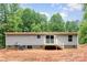 Rear exterior featuring a small deck, sliding glass door and wood siding at 1785 Doe Ct, Iron Station, NC 28080