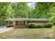 Charming brick home with mature trees, covered carport, and blooming bushes in the front yard at 1874 Sunny Ln, Lancaster, SC 29720