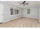 Bright living room with large windows, wood-look floors, neutral paint and a ceiling fan at 1874 Sunny Ln, Lancaster, SC 29720
