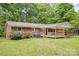 Brick home showcasing a covered porch and spacious green backyard at 1874 Sunny Ln, Lancaster, SC 29720