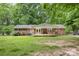 Brick home featuring a covered back porch and spacious green yard at 1874 Sunny Ln, Lancaster, SC 29720