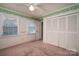 Bedroom featuring carpet, neutral walls, a ceiling fan, green accents, and double closets at 2240 Armstrong Park Dr, Gastonia, NC 28054