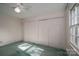 Bright bedroom featuring light green carpet, neutral walls, ceiling fan, and double closets at 2240 Armstrong Park Dr, Gastonia, NC 28054