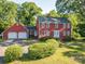 Charming two-story red home with a two car garage and lush landscaping creating a welcoming curb appeal at 2240 Armstrong Park Dr, Gastonia, NC 28054