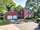 Charming two-story red home with attached two-car garage and a well-manicured front yard at 2240 Armstrong Park Dr, Gastonia, NC 28054