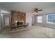 Carpeted living room featuring a brick fireplace, a ceiling fan, and natural light from the windows at 2240 Armstrong Park Dr, Gastonia, NC 28054