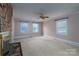 Cozy living room showcasing a stone fireplace, windows, and neutral carpet flooring at 2240 Armstrong Park Dr, Gastonia, NC 28054