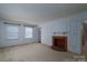 Spacious living room that features two windows, a fireplace, neutral carpet, and white walls at 2240 Armstrong Park Dr, Gastonia, NC 28054