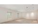 Finished basement area with neutral carpet, bright recessed lighting, and large shuttered windows at 232 Perrin Pl, Charlotte, NC 28207