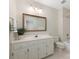 Well-lit bathroom featuring large vanity, decorative mirror, toilet, and shower-tub combo at 232 Perrin Pl, Charlotte, NC 28207