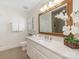 Charming bathroom with white cabinets, decorative mirror, white quartz countertops, and tile floors at 232 Perrin Pl, Charlotte, NC 28207