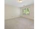Bright, airy bedroom features neutral carpet, white walls, and window views of lush greenery at 232 Perrin Pl, Charlotte, NC 28207