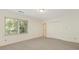 Bright bedroom with neutral carpet, large window, closet, and door for easy access at 232 Perrin Pl, Charlotte, NC 28207