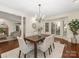 Elegant dining room with a chandelier, bay window, hardwood floors, and fireplace in adjoining room at 232 Perrin Pl, Charlotte, NC 28207