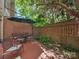 Quaint patio area with brick surround, a round table with chairs, and a shade providing umbrella at 232 Perrin Pl, Charlotte, NC 28207