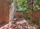 Charming brick patio shaded by a large umbrella and mature trees with seating and privacy wall at 232 Perrin Pl, Charlotte, NC 28207