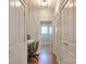 Hallway with a view of a home office and laundry area, showcasing hardwood floors and white trim at 3009 Thayer Dr, Waxhaw, NC 28173