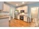 Well-lit kitchen with stainless steel appliances, white cabinetry, and hardwood floors at 3009 Thayer Dr, Waxhaw, NC 28173