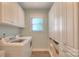 Functional laundry room featuring a washer, dryer, built-in storage, and natural light at 3009 Thayer Dr, Waxhaw, NC 28173