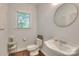 Charming powder room with a pedestal sink, round mirror, and classic fixtures at 3009 Thayer Dr, Waxhaw, NC 28173