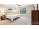 Bright main bedroom with a comfortable bed, bedside tables, large window, and neutral decor for a relaxing ambiance at 3032 Kilbeggan Dr, Clover, SC 29710