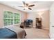 Bright bedroom featuring a ceiling fan, neutral walls, and a modern desk setup with a large window view at 3032 Kilbeggan Dr, Lake Wylie, SC 29710