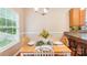 Bright dining area with a wooden table set for four, hardwood floors, and natural light from the window at 3032 Kilbeggan Dr, Lake Wylie, SC 29710