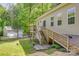 Backyard view with wooden staircase to home, detached garage, and a partially fenced lawn at 3243 Farmcrest Ct, Fort Mill, SC 29708