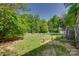 A spacious backyard featuring a wooden fence, fire hydrant, shed and lush greenery at 3243 Farmcrest Ct, Fort Mill, SC 29708