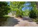 Gravel driveway flanked by mature trees, leading to the home and detached garage at 3243 Farmcrest Ct, Fort Mill, SC 29708