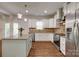 Open kitchen with a center island, white cabinetry, stainless appliances and hardwood floors at 3243 Farmcrest Ct, Fort Mill, SC 29708