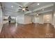 Open concept living space with coffered ceilings, ceiling fans, kitchen, and hardwood floors at 3243 Farmcrest Ct, Fort Mill, SC 29708