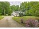 Spacious home featuring a large driveway, two-car garage, lush greenery, and blooming flowerbeds at 3585 Goodman Lake Rd, Salisbury, NC 28146