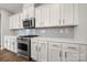 Modern kitchen with white cabinets, stainless steel appliances, and hardwood floors at 3588 County Down Ave, Kannapolis, NC 28081