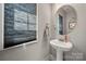 This powder room features a pedestal sink, oval mirror, and window with privacy blinds at 3588 County Down Ave, Kannapolis, NC 28081