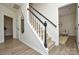 Bright hallway showcases a staircase with black railings and neutral-toned flooring at 3602 Brookstone Trl, Indian Trail, NC 28079