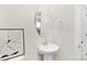 Charming powder room featuring a pedestal sink, round mirror, and decorative wall art at 363 Cedar Knoll Cir, Pineville, NC 28134