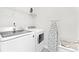 Efficient laundry room featuring modern washer and dryer units and an ironing board for convenient chore management at 363 Cedar Knoll Cir, Pineville, NC 28134