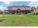 Spacious backyard featuring a covered patio with an outdoor kitchen and a large grassy area at 4071 Thames Cir, Fort Mill, SC 29715