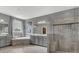 Elegant bathroom with a standalone soaking tub, glass-enclosed shower, and dual sink vanity with gray cabinets at 4071 Thames Cir, Fort Mill, SC 29715