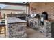 Outdoor kitchen with stone countertops, built-in grill, smoker, and bar seating for entertainment at 4071 Thames Cir, Fort Mill, SC 29715