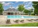 Relaxing community pool with lounge chairs, umbrellas, and a clubhouse nearby at 4208 Carl Parmer Dr, Harrisburg, NC 28075