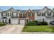 Charming townhouse with brick and siding exterior, complemented by a well-maintained lawn and attached garages at 4208 Carl Parmer Dr, Harrisburg, NC 28075