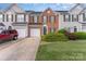 Charming townhome with brick facade, attached garage, green lawn, and inviting curb appeal at 4208 Carl Parmer Dr, Harrisburg, NC 28075
