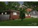 View of the back of a brick home with a wooden fence and some landscaping at 4623 Drifter Dr # 30, Charlotte, NC 28227